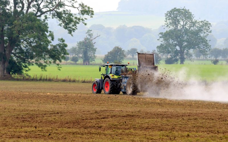 Hoddom, Scotland - September 6, 2021 : Claas tractor with manure spreader spreading manure